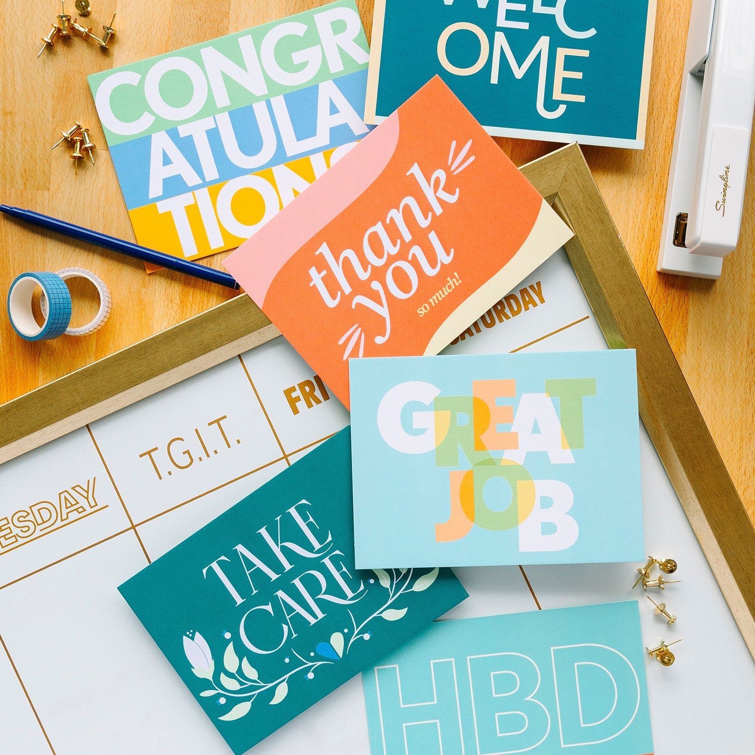 Collection of professional greeting cards placed on a desk among scattered office supplies.